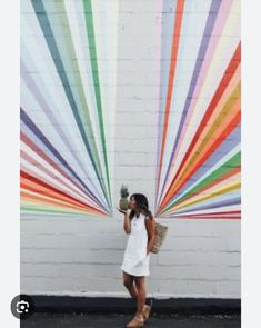 a woman standing in front of a colorful wall