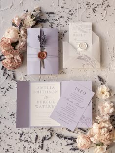 the wedding stationery is laid out with flowers