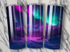 three stainless steel tumblers with an image of the aurora bore in purple and green