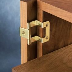 a close up of a wooden door with two brass latches on the front and side