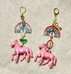 Step into a world of whimsy and color with these delightful statement earrings! Each earring features a glossy pink horse charm, prancing beneath a dazzling rainbow. Adorned with fun, eclectic charms like stars, keys, and flowers, these earrings bring joy and magic to any outfit. The vibrant beads and delicate details, from the shimmering crystal accents to the cute little heart and daisy charms, make these earrings a true conversation piece. Perfect for adding a splash of color to your everyday Pink Horse, Festival Mode, Horse Earrings, Glossier Pink, Daisy Charm, Rainbow Earrings, Delicate Details, Metal Charm, Conversation Piece