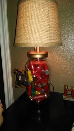 a lamp that is on top of a table next to a jar filled with candy