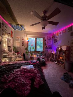 a bedroom with purple lights and pictures on the wall above the bed in front of a window