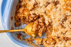 a close up of a plate of food with a spoon in it and crumbs on the side