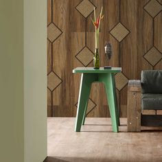 a green table sitting in front of a wooden wall with geometric designs on the walls