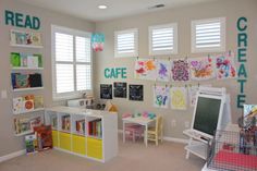 a child's playroom with bookshelves, desks and toys on the wall