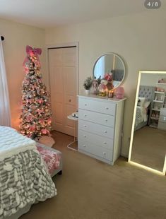 a bedroom with a christmas tree in the corner and a mirror on the wall next to it