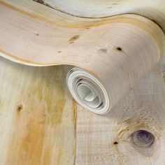 a skateboard laying on top of a wooden floor next to a roll of paper