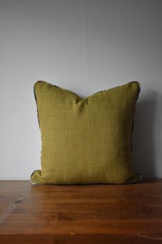 a yellow pillow sitting on top of a wooden table