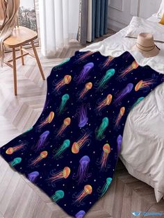 a blanket with jellyfishs on it is laying on the floor next to a bed