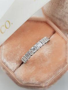 a diamond ring sitting on top of a pink fur covered slip - on shoe with the word co written across it