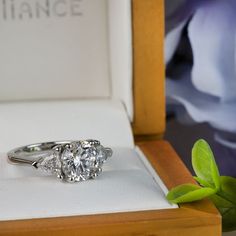 a three stone diamond ring in a box