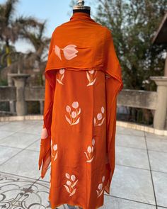 an orange dress with white flowers on it