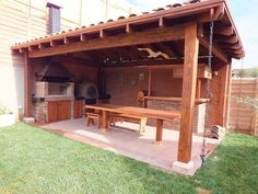 an outdoor bbq with picnic table and grill