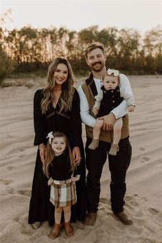 a man, woman and child are standing in the sand