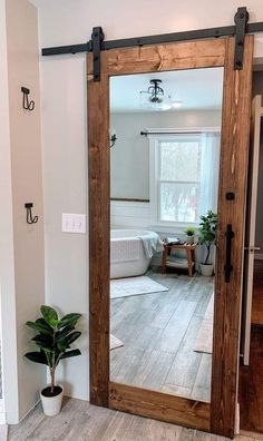 a large mirror sitting on the side of a wall next to a potted plant