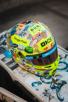 a helmet is sitting on top of a skateboard with stickers all over it