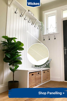 an entryway with hooks and baskets on the wall, next to a potted plant