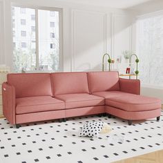 a pink couch sitting on top of a white floor next to a black and white polka dot rug