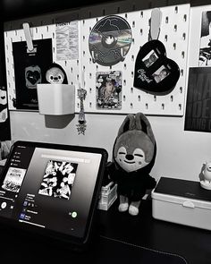 a stuffed animal sitting on top of a table next to a tablet