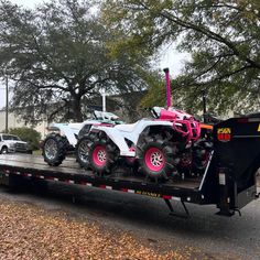 a flatbed trailer with two atvs on it