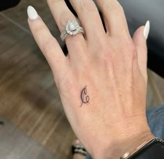 a woman's hand with a small tattoo on it