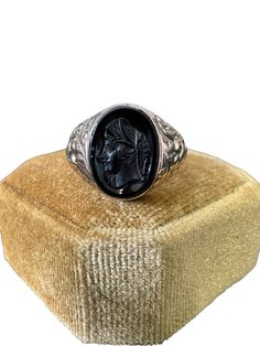 Lovely vintage 10k rose gold onyx cameo ring with a detailed intaglio of a soldier, circa 1907! The bezel set black gemstone cameo is oval cut. Unique piece of fine vintage jewelry, over 100 years old! ERA - Circa 1907 / Edwardian Era METAL / MATERIAL - 10k rose gold, onyx MARKINGS / HISTORY - RFB Oct 19-07 CONDITION - Good vintage condition. Piece has been professionally cleaned and lightly polished. The carved cameo is intact and secure in setting. Small chips on stone. Age appropriate wear to metal including scratch to back of ring head. Amazing Edwardian era ring! SIZE / MEASUREMENTS - Size: 8 1/2, Ring head height: 15 mm, Band: tapers to 3 mm, Weight: 3.8 grams (Ring can be resized within reason by our local jeweler or likely yours. Please contact us prior to purchasing if you are int Black Victorian Engraved Ring, Antique Black Signet Ring Collectible, Victorian Black Oval Signet Ring, Black Oval Victorian Signet Ring, Black Victorian Oval Signet Ring, Black Victorian Signet Ring Collectible, Antique Black Cabochon Rings, Victorian Style Black Signet Ring Collectible, Vintage Black Cameo Ring