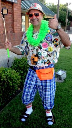 a man dressed up as a clown holding a green frisbee and giving the thumbs up