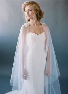 a woman in a wedding dress with a veil on her head