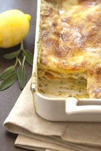 a casserole dish on a napkin next to a lemon and bay leaf decoration