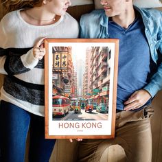 a man and woman are holding up a sign with the words hong kong on it