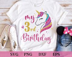 a unicorn birthday shirt with the number one on it, next to some other items