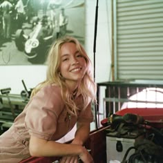 a woman leaning on the back of a red car