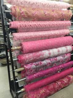 a rack full of pink and gold fabrics