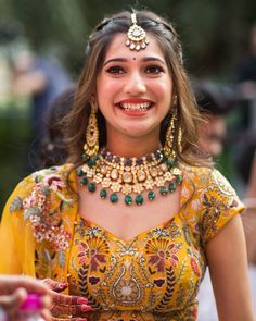 a woman in a yellow dress smiles while holding something