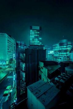 a city at night with tall buildings lit up in the distance and cars parked on the street