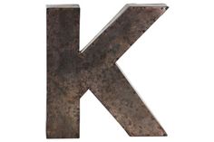 the letter k is made out of metal and has rusted pattered paint on it