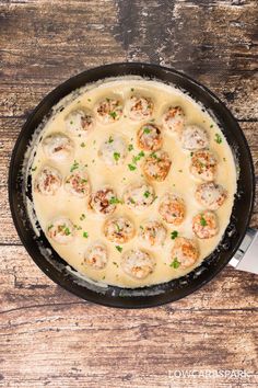 chicken meatballs alfredo in a cast iron skillet on a wooden table with text overlay