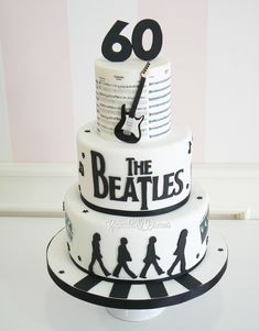 the beatles cake is decorated with black and white designs on it's tiers