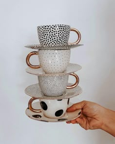 a stack of coffee mugs sitting on top of each other in front of a white wall