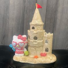 a hello kitty figurine next to a sand castle