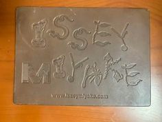 a metal plate with the words ms and y on it, sitting on a wooden table