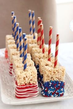 some rice krispy treats are on a plate with red, white and blue straws