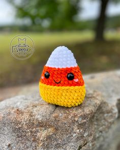 a crocheted toy sitting on top of a rock