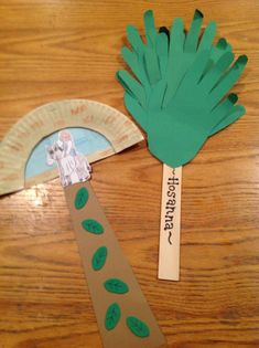 a paper plate and palm tree cut out on a wooden table with a name tag