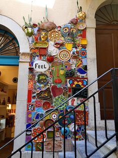 an artisticly decorated wall on the side of a building with stairs leading up to it