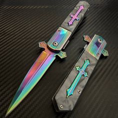 two multicolored knifes sitting on top of a black table next to each other