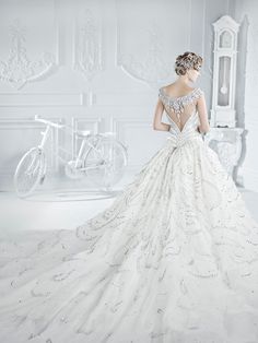 a woman in a wedding dress standing next to a bike