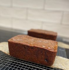 two pieces of brown bread sitting on top of a cooling rack next to each other