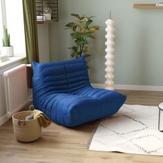 a living room with a blue chair and white rug